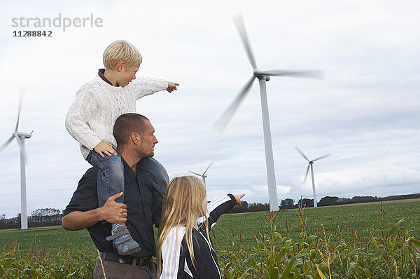 Vater und Kinder mit Blick auf Windkraftanlagen  Dänemark