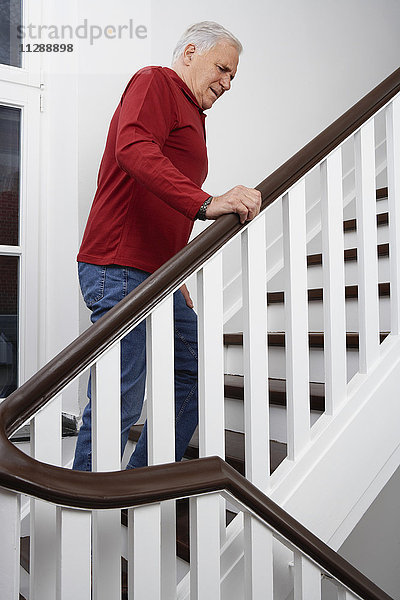 Mann mit Schmerzen  Treppe kletternd