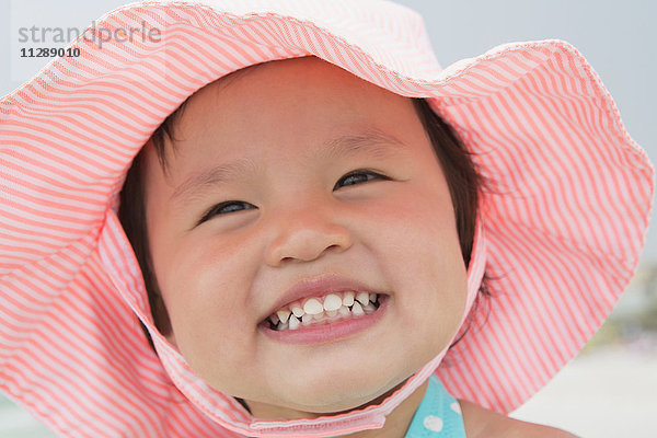 Nahaufnahme Porträt von Kleinkind Mädchen trägt Sonnenhut und lächelnd am Strand  Destin  Florida  USA