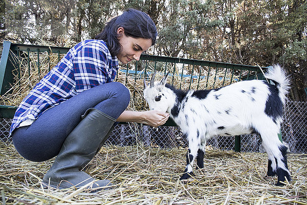 Frau beim Füttern einer Ziege auf einem Bauernhof