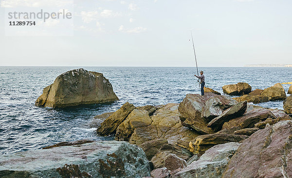 Senior Mann beim Fischen am Meer