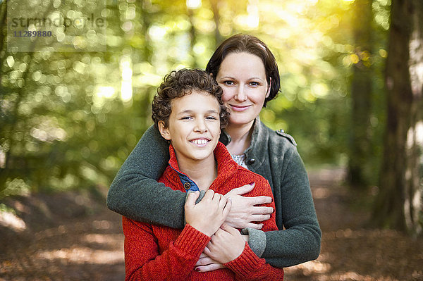 Porträt von lächelnder Mutter und Sohn im Herbstwald