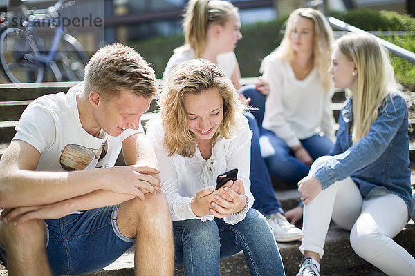 Freunde sitzen zusammen auf einer Treppe