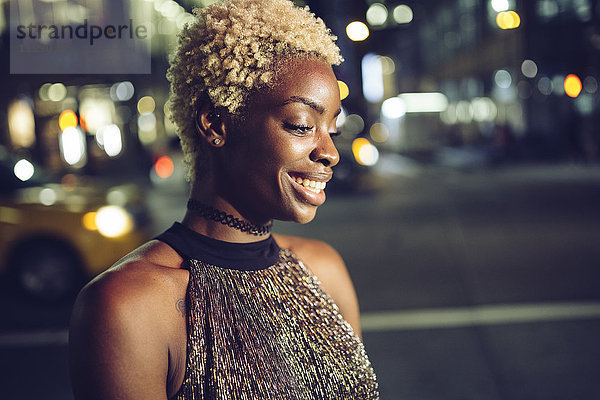 USA  New York City  Porträt der glücklichen jungen Frau am Times Square bei Nacht