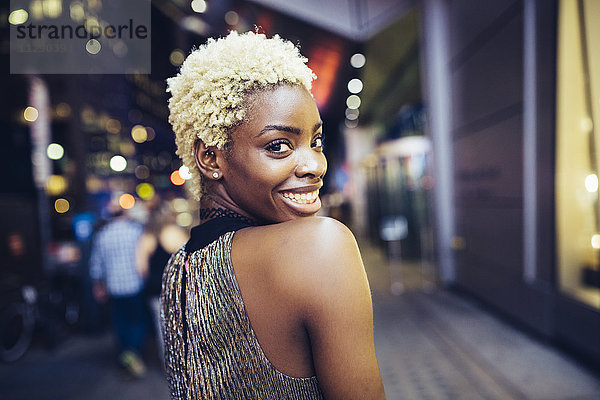 USA  New York City  lächelnde junge Frau am Times Square bei Nacht