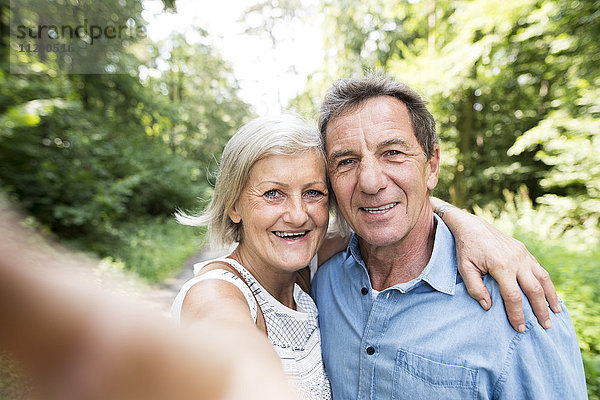 Glückliches älteres Paar  das Selfie in den Wäldern nimmt.
