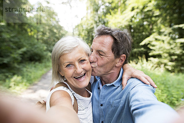 Glückliches älteres Paar  das Selfie in den Wäldern nimmt.