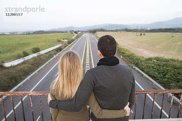 Paar auf der Brücke mit Blick auf die Autobahn