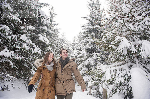 Glückliches Paar beim Wandern im Winterwald