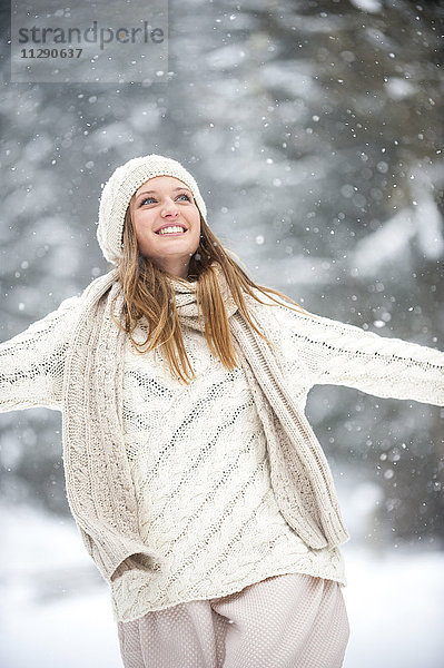 Porträt einer lächelnden blonden Frau in Strickwaren im Winter