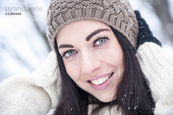 Porträt einer lächelnden Frau in Strickwaren im Winter