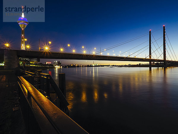 Deutschland  Düsseldorf  Blick auf beleuchtete Rheinknie-Brücke und Fernsehturm bei Nacht