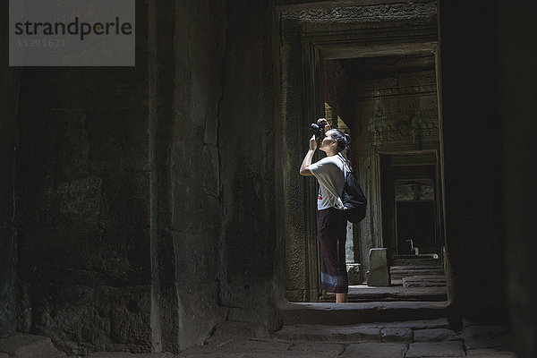 Kambodscha  Siem Reap  Angkor Thom  Touristen fotografieren Bayon-Tempel mit Kamera