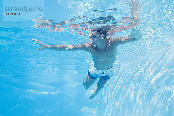 Junger Mann unter Wasser im Pool