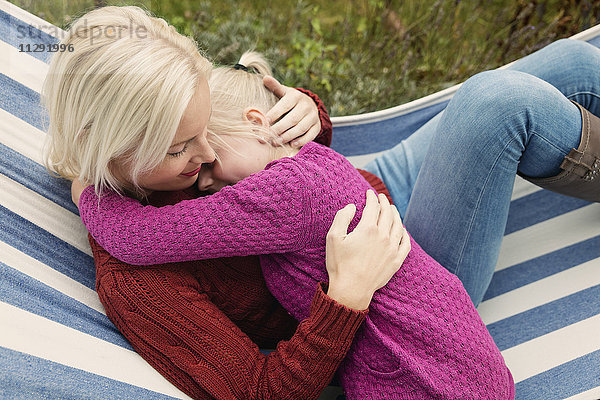 Mutter und Tochter entspannen gemeinsam in einer Hängematte