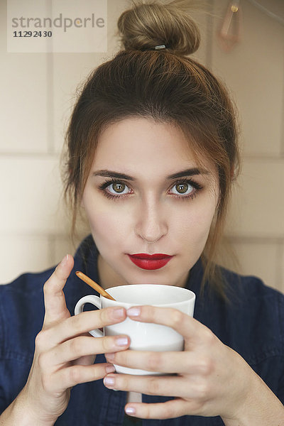 Porträt einer jungen Frau mit einer Tasse Kaffee