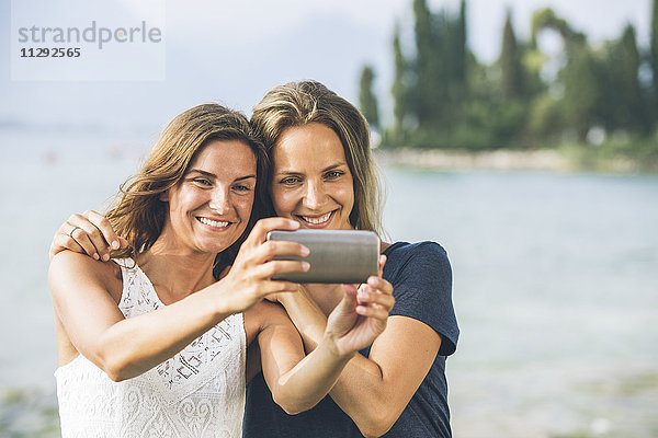 Italien  Gardasee  zwei junge Frauen mit einem Selfie
