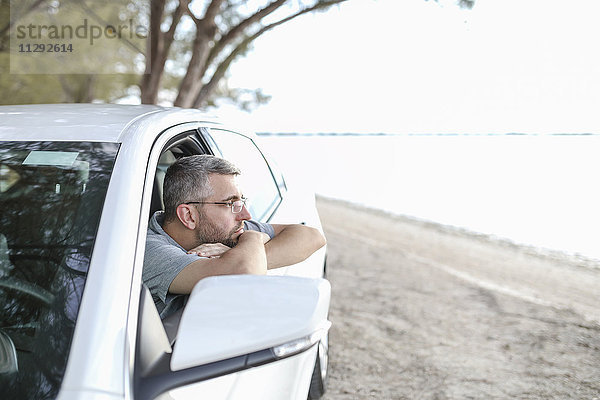 Mann im Auto sitzend  eine Pause machend