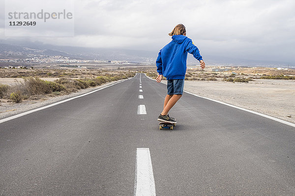 Spanien  Teneriffa  Rückansicht von Boy Skateboarding auf leerer Landstraße