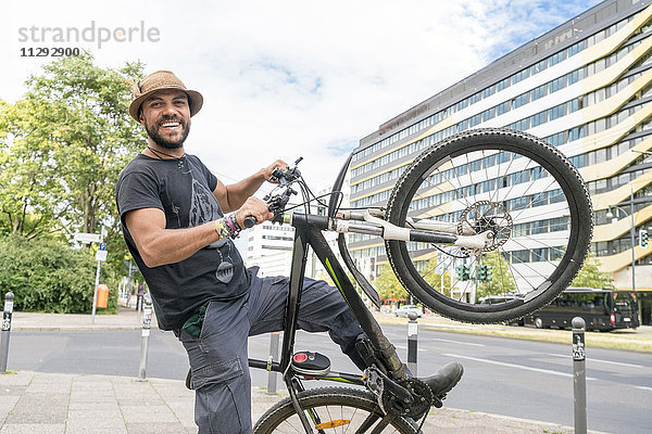 Porträt eines lächelnden Mannes mit Fahrrad