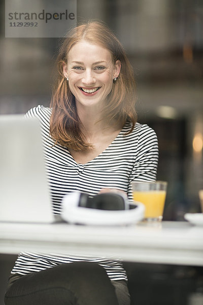 Porträt einer glücklichen Frau  die in einem Café sitzt.