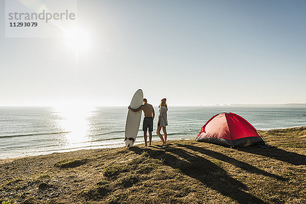 Junges Paar mit Surfbrett-Camping am Meer