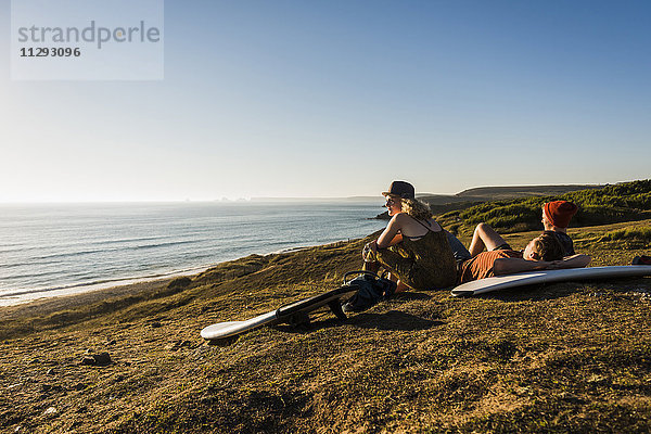 Drei Freunde mit Surfbrettern zum Entspannen am Meer