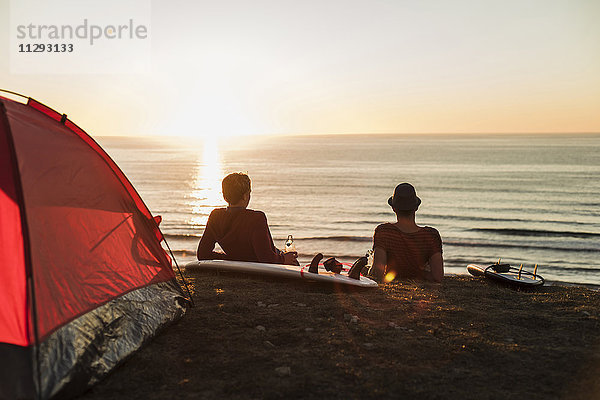 Zwei beste Freunde genießen den Sonnenuntergang am Strand