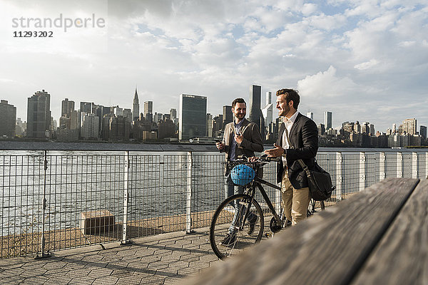 USA  New York City  zwei Geschäftsleute mit Fahrrad entlang des East River