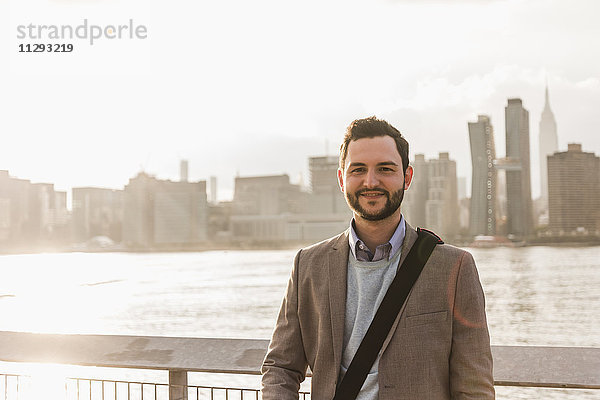 USA  New York City  Porträt eines selbstbewussten Geschäftsmannes am East River