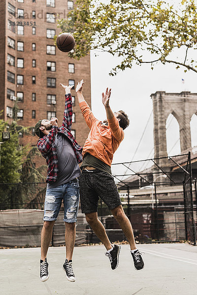 USA  New York  zwei junge Männer beim Basketball auf einem Außenplatz