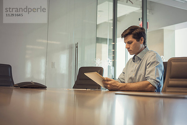 Geschäftsmann im Büro sitzend  mit digitalem Tablett
