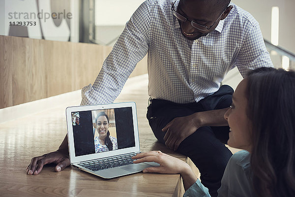 Geschäftsleute mit einer Videokonferenz am Laptop