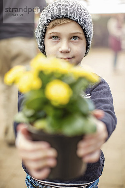 Junge mit gelbem Blumentopf