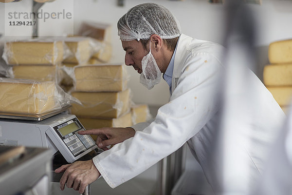 Käsereiarbeiter beim Wiegen von verpacktem Käse