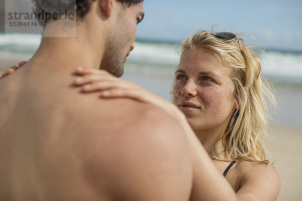 Zartes junges Paar am Strand stehend