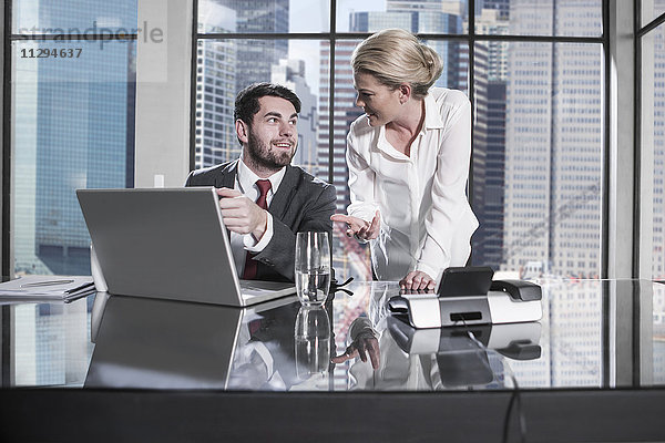 Geschäftsmann und Frau in der Sitzung diskutieren im Büro  mit Laptop