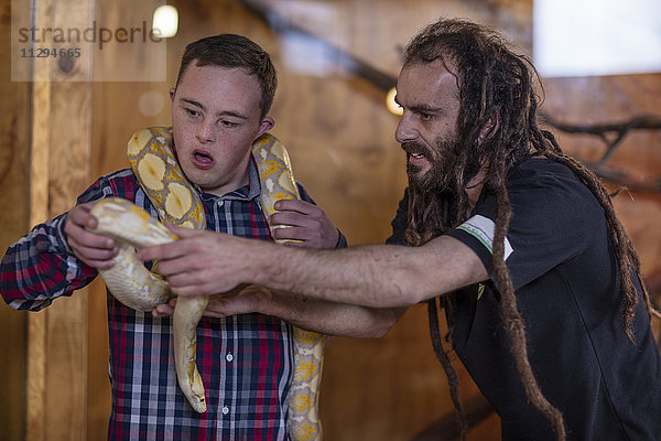 Tierpflegerin übergibt Albino-Pythonschlange an jungen Mann mit Down-Syndrom