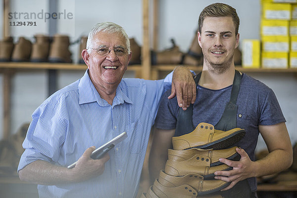 Porträt eines lächelnden älteren Mannes und jungen Mannes mit Schuhen
