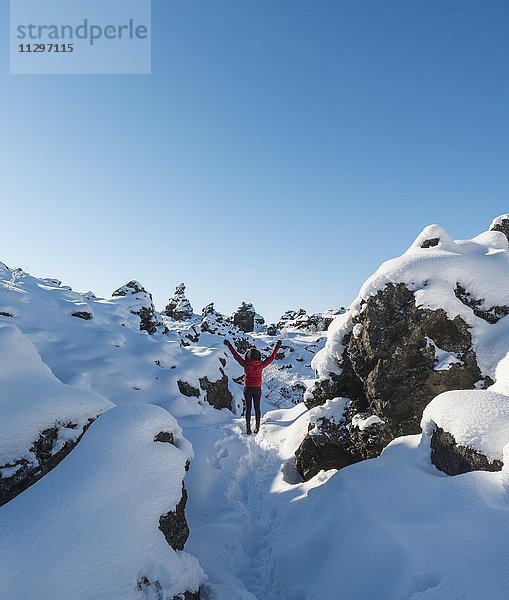 Frau mit ausgestreckten Armen  Schneelandschaft  Lavafeld bedeckt mit Schnee  Vulkansystems Krafla  Dimmuborgir Nationalpark  Mývatn  Nordisland  Island  Europa