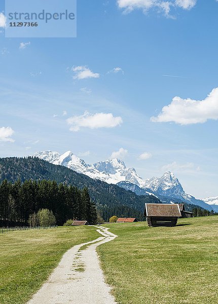 Heustadl auf Wiese an einem Feldweg  hinten Karwendelgebirge mit Schnee  Werdenfelser Land  Oberbayern  Bayern  Deutschland  Europa