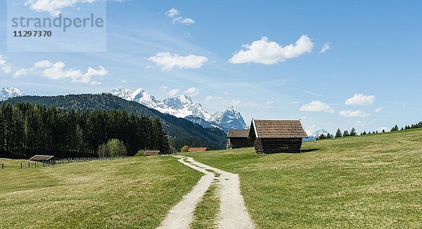 Heustadl auf Wiese an einem Feldweg  hinten Karwendelgebirge mit Schnee  Werdenfelser Land  Oberbayern  Bayern  Deutschland  Europa