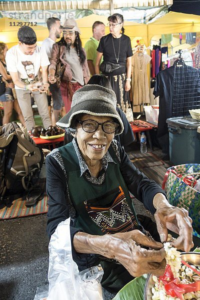 Alte Frau  Thailänderin  verkauft Blüten und Blütenketten am Nachtmarkt  Krabi Stadt  Krabi  Thailand  Asien