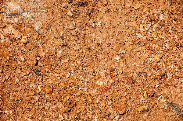 Rötlicher Lehmboden mit kleinen Steinen  formatfüllend