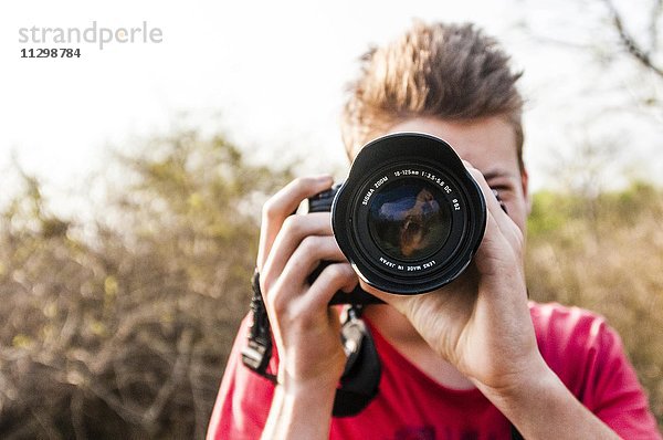 Junge fotografiert mit einer Spiegelreflexkamera