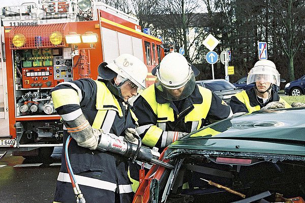 Feuerwehr bei Verkehrsunfall  Fahrer im Auto eingeklemmt  Einsatz der Rettungsschere  München  Oberbayern  Bayern  Deutschland  Europa