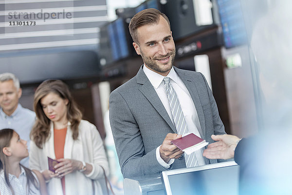 Geschäftsmann mit Reisepass am Flughafen-Check-in-Schalter