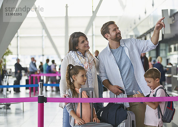 Familie mit Koffern in der Flughafenhalle