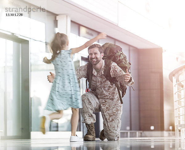 Tochter läuft und begrüßt Soldatenvater in der Flughafenhalle