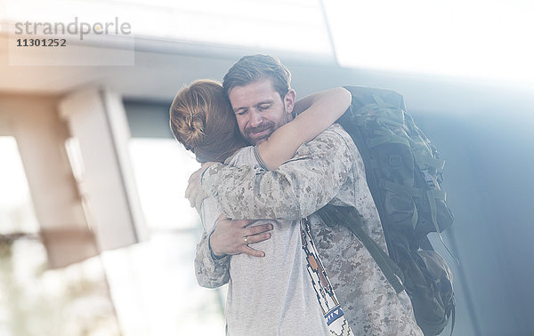 Begrüßung der Frau und Umarmung des Soldaten-Ehemannes am Flughafen